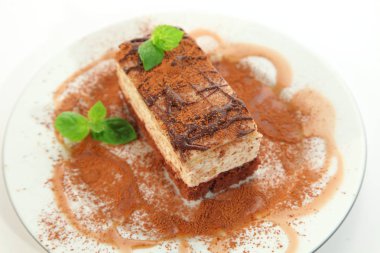 Parça çikolatalı cheesecake plaka üzerine dekore edilmiştir.