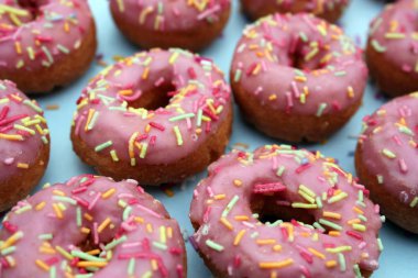 çörek çörekler çörekler pembe parlak şeker iplikçikleri arka plan 100s ve binlerce dekorasyon stok, fotoğraf, fotoğraf, resim, resim üzerine serpin,