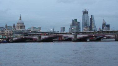 Londra, İngiltere - 02.02.2022: Thames nehri boyunca uzanan Milenyum köprüsü görüntüsü, durgunluktan hareketlilik, hem köprüde yürüyen nehir dalgalanması yapan insanların görüntüsü Londra şehrinin popüler turizm ve turizm simgeleri. 