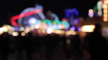 Disko ışıkları lunapark bokeh arka planda sentetik gökkuşağı bokeh ışıkları gece stoklarında yanıp sönen insanlar, video, klip