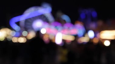 Disko ışıkları lunapark gezisi sentetik dalga gökkuşağı bokeh ışıkları gece stoklarında, görüntülerde, videolarda yanıp sönen insanları hareket ettiriyor.