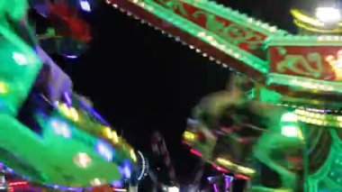 Disko ışıkları lunapark bokeh biniciliği sentetik dalga gökkuşağı bokeh ışıkları gece stoklarında yanıp sönen insanlar, video, klip
