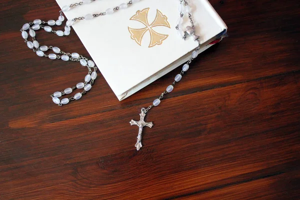 bible and rosary beads for a catholic to pray  background with copy space  - stock photo