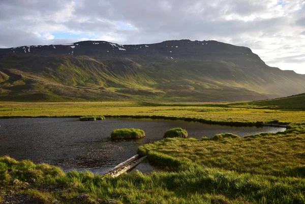 Maravilloso paisaje islandés cerca de la olla caliente Grettislaug en la península Skagi con una montaña y un estanque . — Foto de Stock