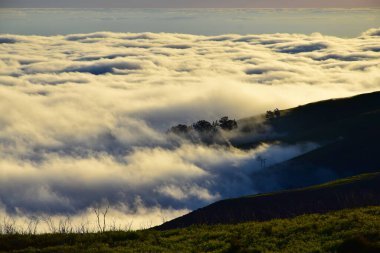 Gün batımında Madeiran manzarası. Okyanustan bir sürü bulut geliyor. Portekiz.