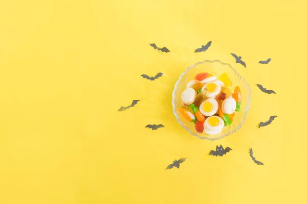 Halloween candy.Halloween holidays on yellow background, colorful decoration toys, baby sweets, donuts, marmalade. trick or treat, terrible night.halloween background