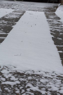 Lastik izlerinin arasındaki bahçede kar vardı.
