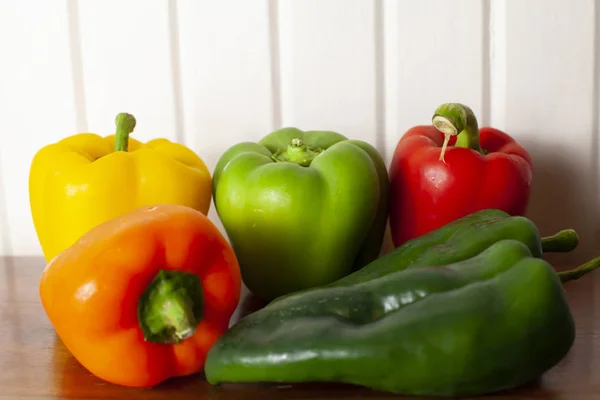 Yellow, green, red, and orange bell peppers with a pair of poblano peppers