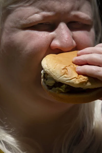 Mujer comiendo una hamburguesa —  Fotos de Stock