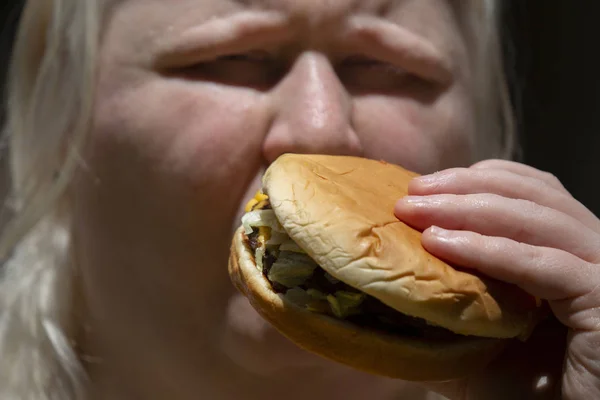 Mujer comiendo una hamburguesa —  Fotos de Stock