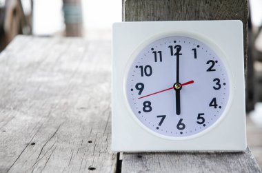 White clock on wooden floor river in the morning.On the river at 6:00 pm, there is a white clock on the wooden floor.