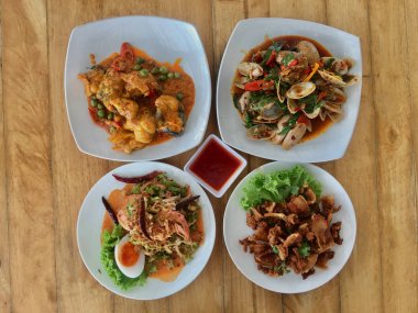 Körili balık, Kızarmış domuz çıtırtı, Kavrulmuş Chili Ezmesi ile Kızarmış İstiridye, Wing Bean Karides Salad.Thai gıda restoranda