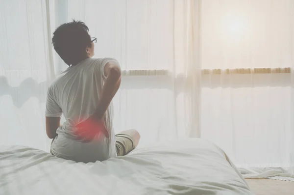 アジアの女性は 朝に背中の痛みを持っています 背中の痛みはマットレスによって引き起こされる オブジェクトに焦点を当てない — ストック写真