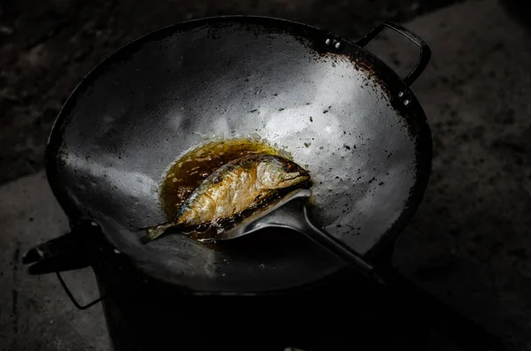 Close up.Fish in the pan.Asians are cooking in the kitchen in the morning.