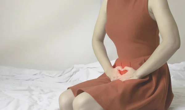 女人穿红色的裙子用手摸阴道 下身是真菌引起的阴部瘙痒 不要把注意力集中在物体上 — 图库照片