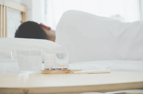 アジアの男性は 午前中に部屋の白いベッドの上に横たわって病気 寝室に男が寝ていた暖かいトーン オブジェクトに焦点を当てない — ストック写真