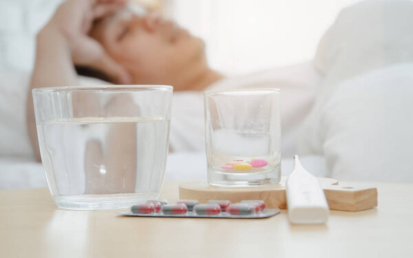 Азиатские мужчины больны Ли на белой кровати в комнате по утрам.
.