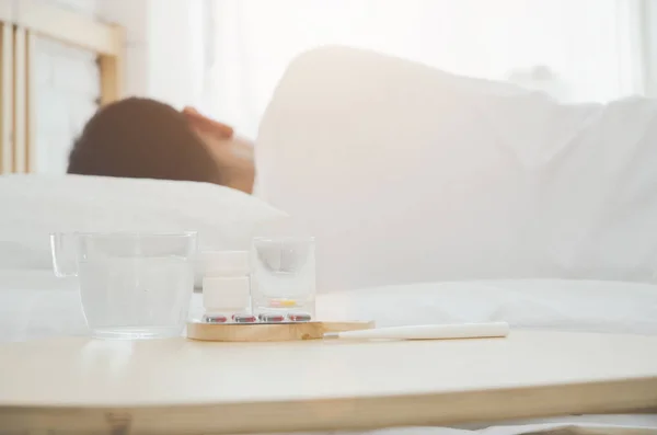 アジアの男性は 午前中に部屋の白いベッドの上に横たわって病気 寝室に男が寝ていた暖かいトーン オブジェクトに焦点を当てない — ストック写真