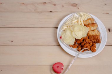 Beyaz plakalı cipsi kızartılmış yiyecek bel hattı masada. Sağlıklı yeme ve aktif yaşam tarzı kavramı. Nesnelere odaklanmayın.