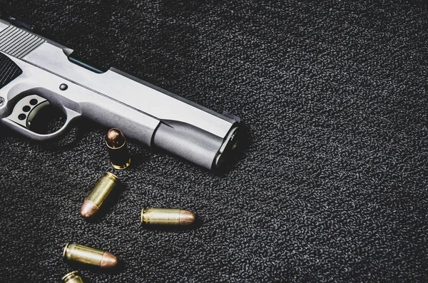 Silahlar ve mühimmat siyah bir arka planda yerleştirilir. Tek renkli ton. Nesnelere odaklanmayın