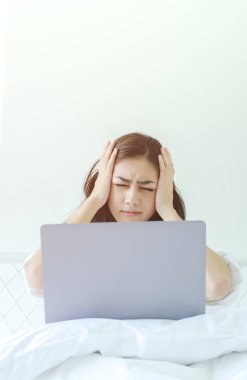 Asyalı kadınlar şiddetli baş ağrısı vardır. Bayan sabah migrenle uyanır. Uykusuzluk uyandığında baş ağrısına neden oluyor. Stresli bir yatakta oturan genç kız. Bu görüntünün ana nesnesi üzerinde durulmayın.