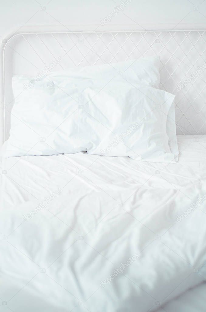 The white bed is in the sun-warmed bedroom in the morning. White bedroom in the morning.Do not focus on objects.