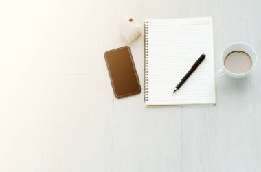 Kitabın yere siyah bir akıllı telefon yerleştirilmiş siyah bir kalemi var. Boş alanı kopyala.