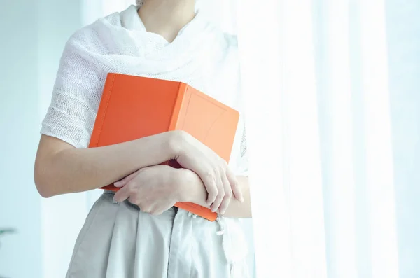 Ένα Πορτοκαλί Βιβλίο Στα Χέρια Μιας Γυναίκας Μην Εστιάζεις Στο Εικόνα Αρχείου