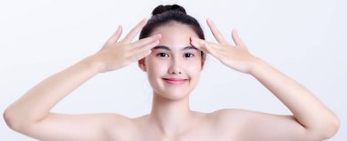 Asyalılar çekicidir, gülümserler ve cilt sağlıkları iyidir. Beyaz arka planda izole edilmiş, güzellik için kozmetik konsept..