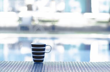 Mavi kahve fincanı Sabah havuzun kenarındaki masaya koy.