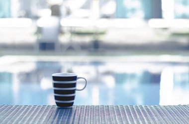 Mavi kahve fincanı Sabah havuzun kenarındaki masaya koy.