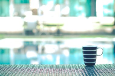 Mavi kahve fincanı Sabah havuzun kenarındaki masaya koy.