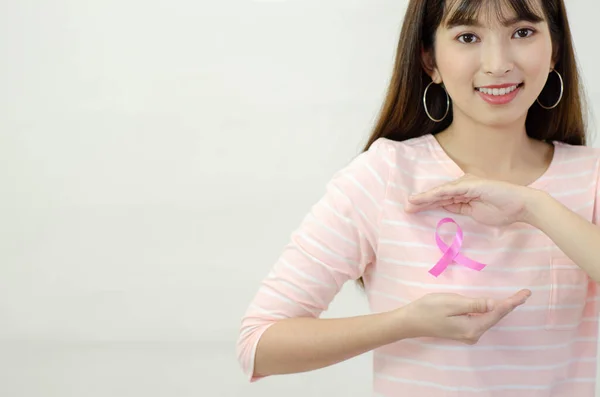 在亚洲女人的衬衫上贴上粉红色的缎带 不要把焦点放在物体上 世界乳腺癌日的概念 图库照片