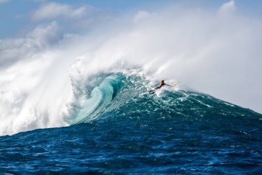 Hawaii'de dev bir dalganın üzerinden geçiyor bir Sörfçü
