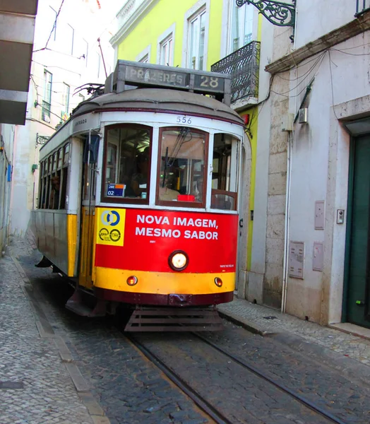 Исторический трамвай нет. 28 между узким домом альфамы Лиссабонской, Португалия — стоковое фото