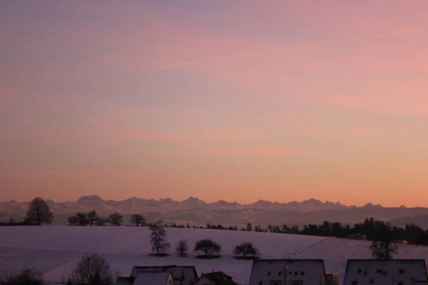 Pôr do sol colorido incrível em uma noite de inverno com montanhas no fundo — Fotografia de Stock