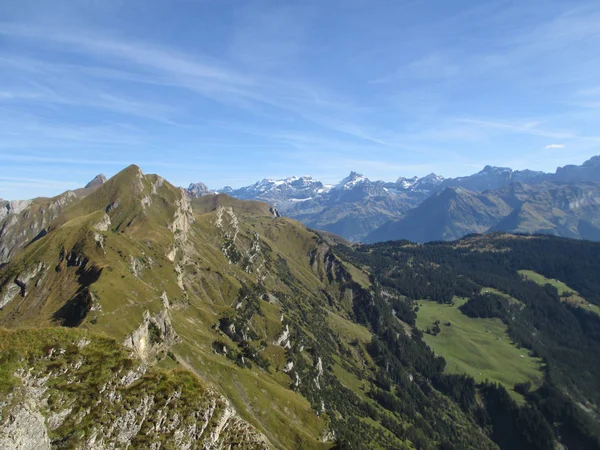 На вершине горы в швейцарских Альпах с панорамой горы на заднем плане — стоковое фото