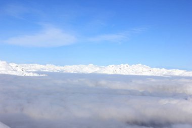 British Columbia'da sis üzerinde karla kaplı dağlar