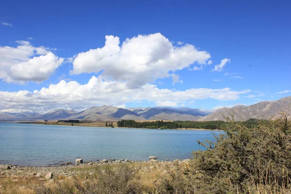 Lago Tekapo em um dia ensolarado com algumas nuvens — Fotografia de Stock