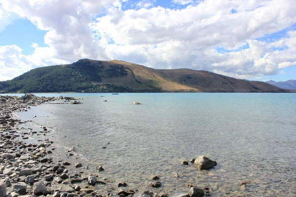 Bord du lac tekapo en Nouvelle-Zélande avec une montagne en arrière-plan — Photo