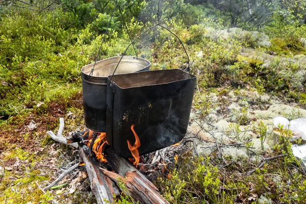 Μαγείρεμα τροφίμων σε συνθήκες αγρού, σε καπνιστά καζάνια πάνω από φωτιά σε δάσος σε ξέφωτο. — Φωτογραφία Αρχείου
