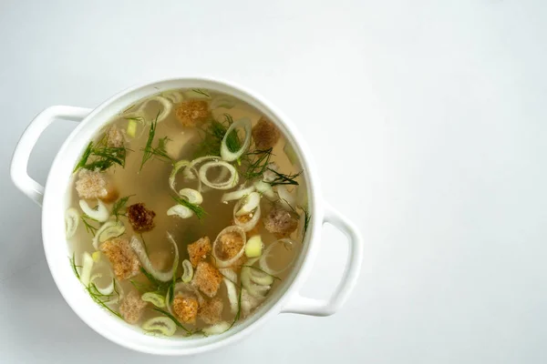 Caldo de carne hecho en casa en una espiga con eneldo, cebolla y croutons. sobre un fondo blanco. Concepto de comida saludable. Vista superior. — Foto de Stock