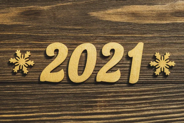 New Year 2021. Gold numbers and decorations in the form of snowflakes on a dark wooden table. Merry Christmas.Copy space — Stock Photo, Image