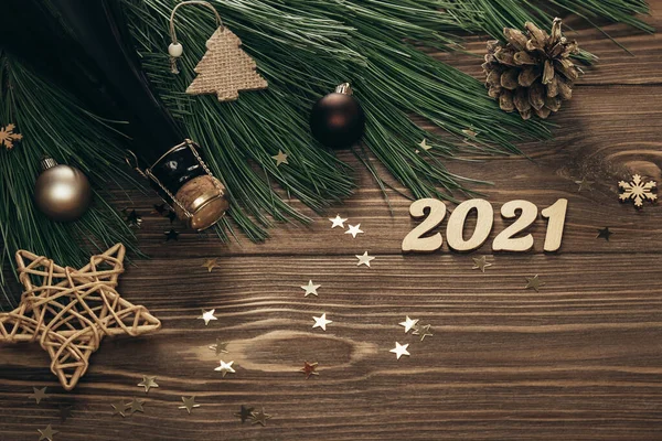 モミの枝、黄金の数字、シャンパンと木製の背景に装飾が施されたクリスマスカード。コピースペース。平敷 — ストック写真