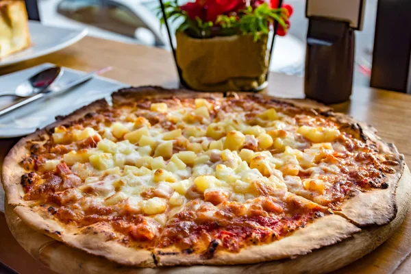 Hawaiian Pizza , pineapple , ham,  cheese and tomato sauce on old on wooden plate