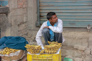 Nepal, Mayıs 2017. Nepalli bir adam yolun yanında oturur ve muz satar..