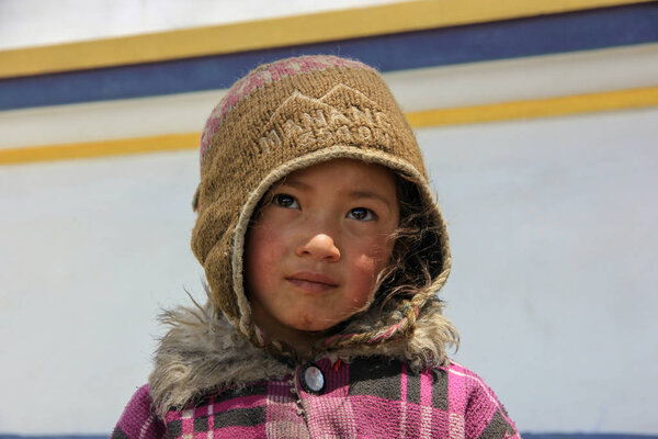 Nepal, May 2017. Little girl in a brown hat on the street of Nepal.