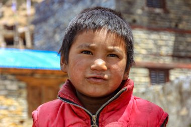 Nepal, Mayıs 2017. Nepal caddesinde kirli suratlı kırmızı ceketli çocuk.