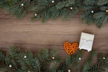 Noel arkaplanı. Noel ağacı dalları, hediye, kalpler, toplar ve yıldızlar ahşap dokuda