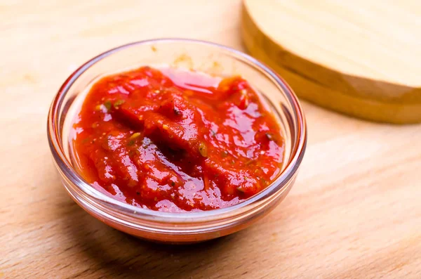 Red ketchup on wooden table — Stock Photo, Image